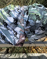 Product image of recycled swim trunks with surfers on them