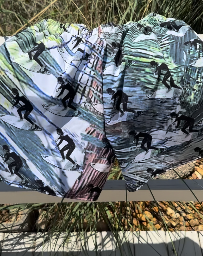 Product image of recycled swim trunks with surfers on them