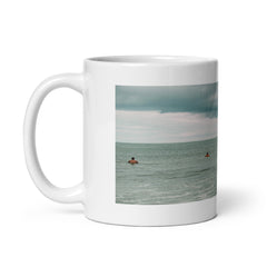Left side view of a white 11oz glossy ceramic mug with a photo of surfers lined up in Florida.